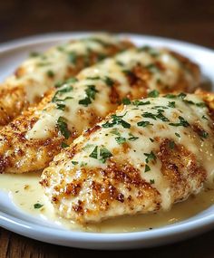 three pieces of chicken covered in sauce on a white plate