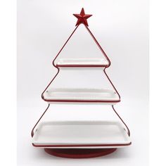 a red and white christmas tree shaped serving platter on a round stand with a star