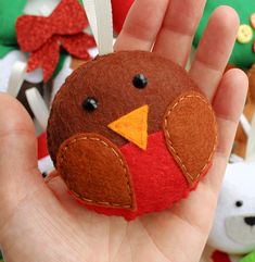 a hand is holding a small bird ornament