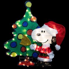 a lighted christmas tree with a snoopy character next to it