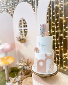 a three tiered cake with an animal topper on it's bottom layer