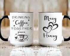 two coffee mugs sitting next to each other on top of a wooden table together