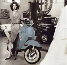 a woman sitting on top of a scooter in a garage