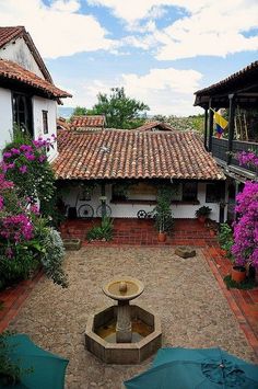 an outdoor courtyard with umbrellas and flowers