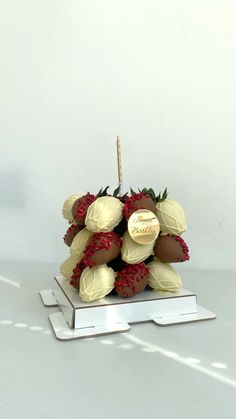 some chocolate covered strawberries are sitting on top of a white plate with a candle