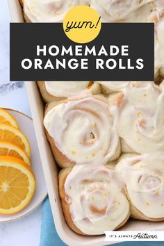 homemade orange rolls with icing in a pan and sliced oranges on the side