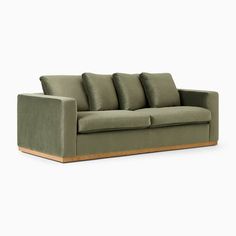 a green couch with four pillows on the back and one arm folded up in front