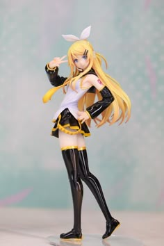 a doll with long blonde hair wearing black and white clothes, holding a yellow object