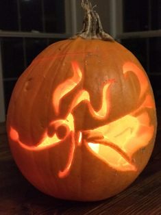 a carved pumpkin sitting on top of a wooden table