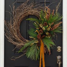 a wreath on the front door with pine cones