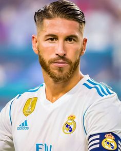 a man with a goatee and beard in a soccer uniform looking at the camera