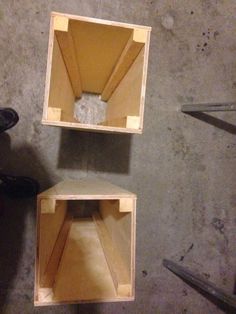 two wooden boxes sitting on top of a cement floor