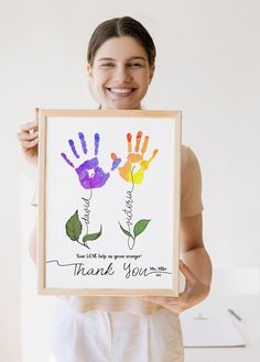 a woman holding up a painting with two hands and the words thank you