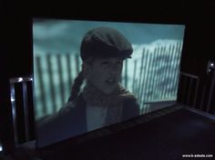 a screen with a woman wearing a hat on it's face in the dark