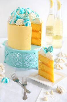 two pieces of yellow cake with blue and white frosting next to each other on plates