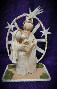 a statue of a woman holding a child in front of a circular object with stars on it