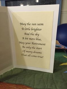 an open card with a poem on it sitting on a table next to a blue ball