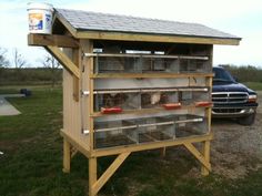 a truck parked next to a wooden structure with chickens in it's cages