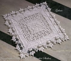 a white doily sitting on top of a black and white striped floor