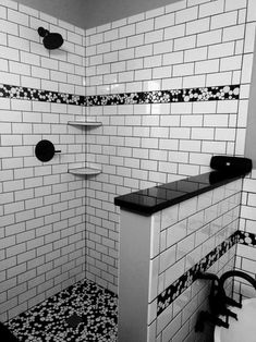 a black and white photo of a tiled bathroom