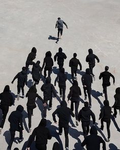 a group of people standing in the middle of a parking lot with one person on a skateboard