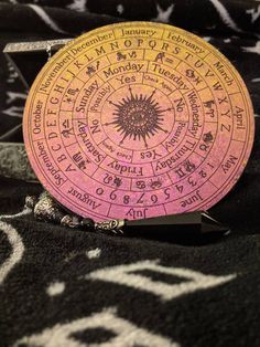 a pink and yellow plate sitting on top of a black table cloth with writing all over it