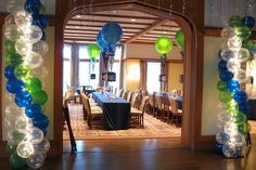 an archway decorated with balloons and streamers in a formal dining room, set up for a party