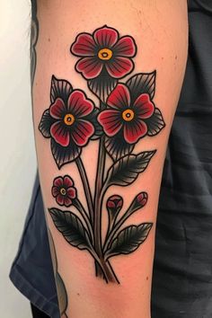 a close up of a person's arm with tattoos on it and flowers in the middle