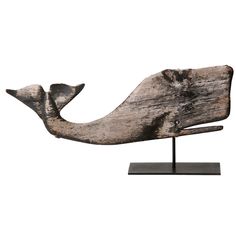 a wooden sculpture of a whale on a stand