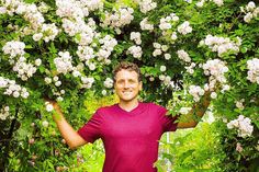 a man standing in front of white flowers