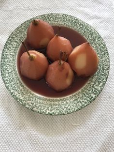 some food is in a green and white bowl on a tablecloth with a cloth