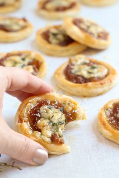 someone is picking up some small pastries from the baking sheet and placing them on top of each other