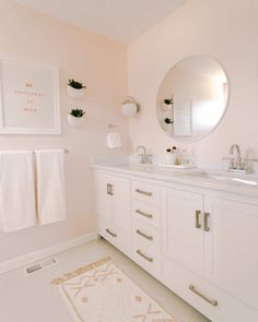 a white bathroom with two sinks and mirrors