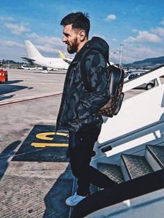 a man with a backpack walking towards an airplane