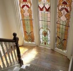 the stairs lead up to three stained glass windows in this home's entryway