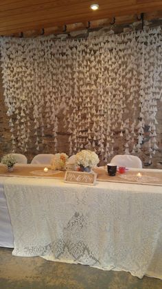 the table is set up with white flowers and candles for guests to sit down at