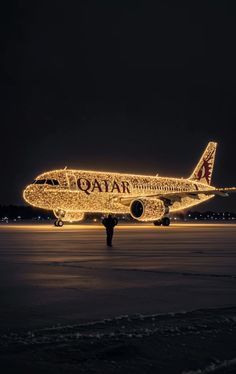 an airplane is lit up with christmas lights