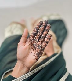 a woman is holding her hands up with hendi tattoos on their palms and fingers