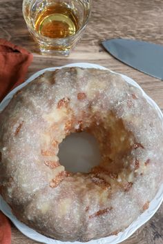 a frosted donut sitting on top of a white plate next to a knife