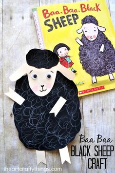 a paper plate with a black sheep on it next to a book and craft stick