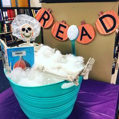 a blue bucket filled with foam next to a sign that reads read and skeleton in the bathtub