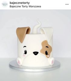 a white cake with a brown dog on it's face and the words bajec - netory written in german