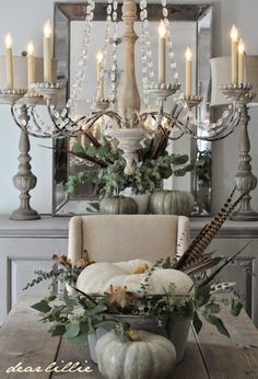 an image of a dining room table with candles and greenery on the centerpiece