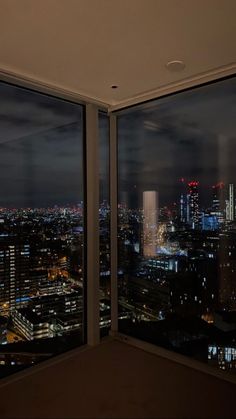 the city lights are lit up at night as seen from an office building in new york