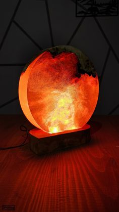 an orange lamp sitting on top of a wooden table next to a red light bulb