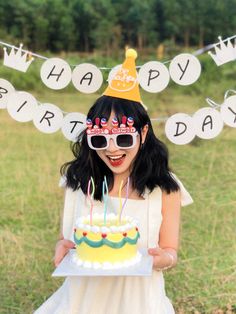 a woman holding a birthday cake in front of her face with the words happy birthday written on it