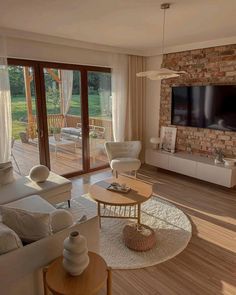 a living room filled with furniture and a flat screen tv mounted on the wall above a fire place