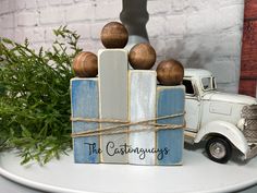 a toy truck with three wooden balls on it's back sitting next to a christmas tree