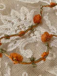 an orange flower on a white lace tablecloth