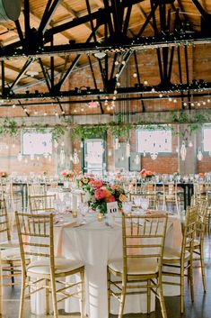 tables and chairs are set up for a wedding reception in an old building with exposed ceilings